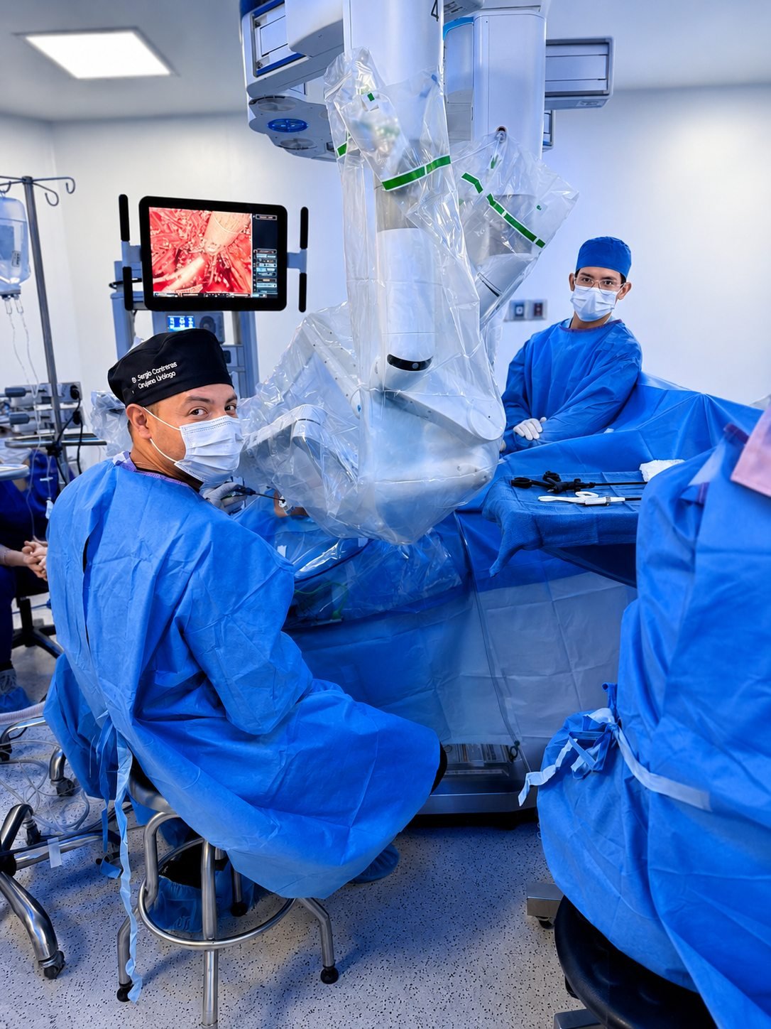 Equipo quirúrgico junto a los brazos del robot Da Vinci en quirófano